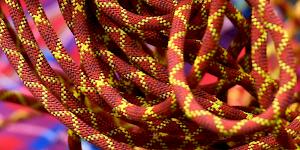 Close up image of red dynamic climbing rope with a yellow cross pattern.